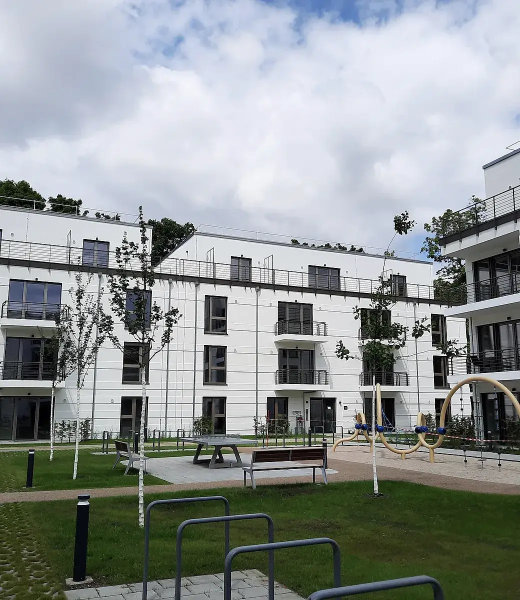 Fertiggestellter Wohnungsneubau mit begrüntem Innenhof und Spielplatz